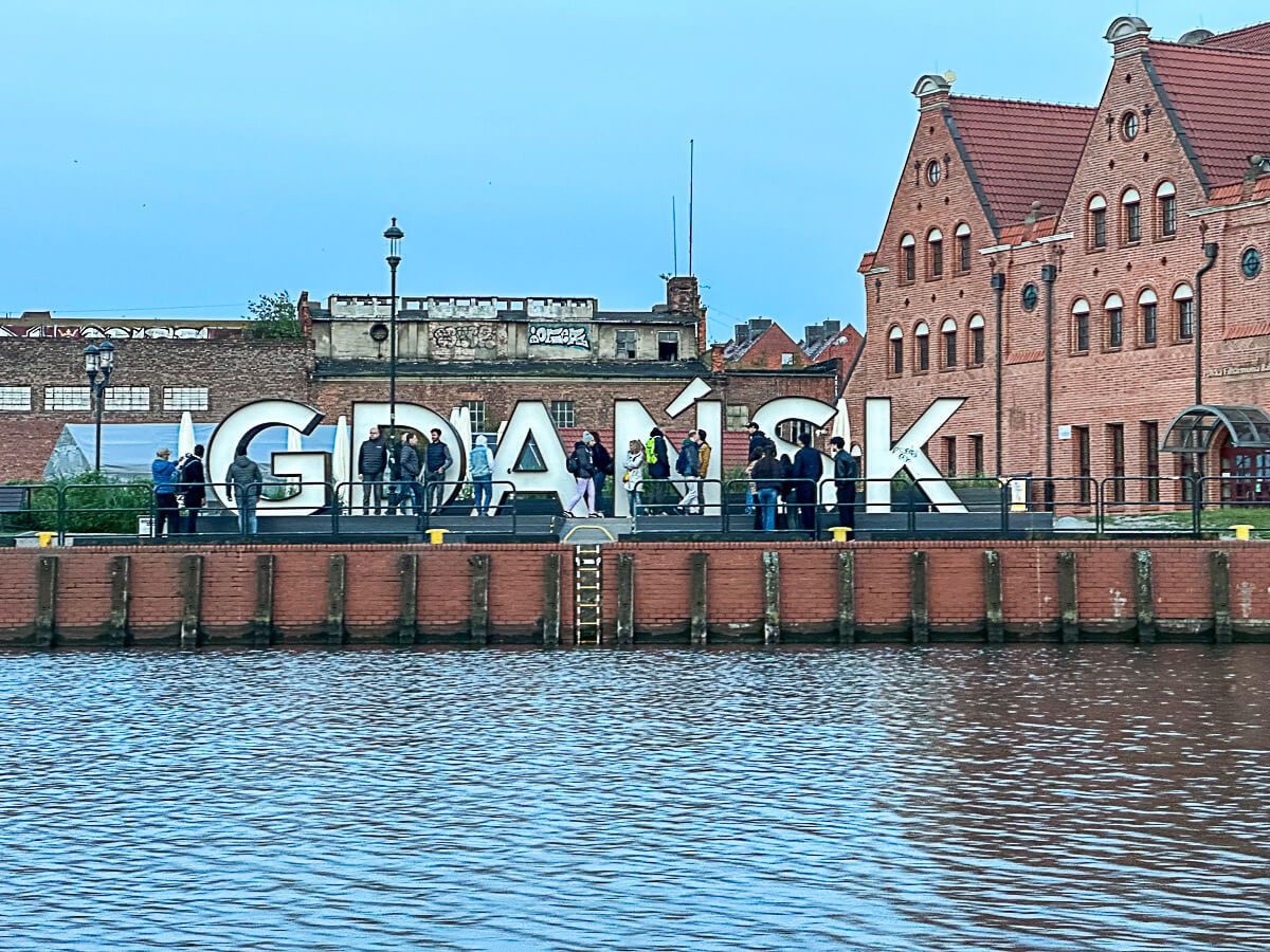 GDANSK in Großbuchstaben vor Häusern am Ufer der Mottlau
