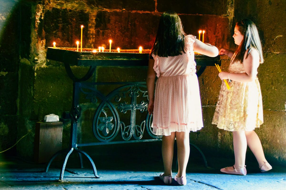 Mädchen zünden Kerzen in einer Kirche in Etschmiadsin/Armenien an