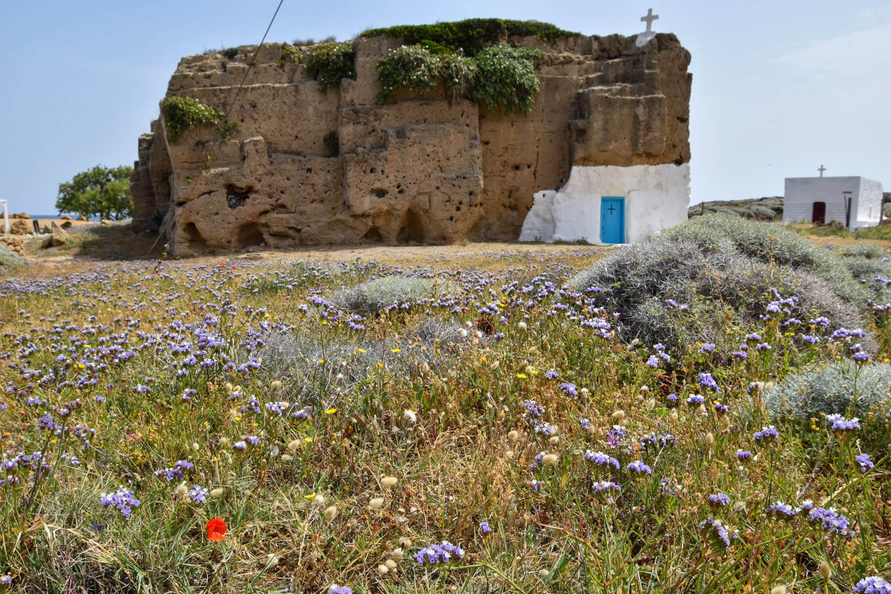 Kirche in einem Felsen, davor Blumenwiese