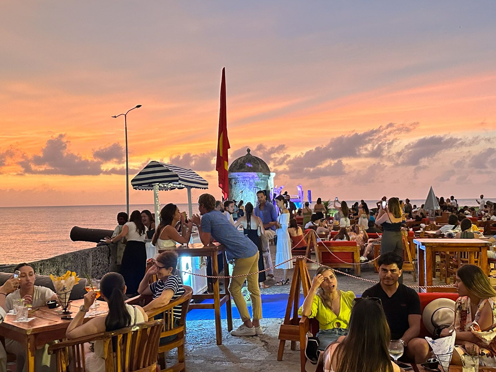 Café Del Mar mit feiernden Menschen bei Sonnenuntergang