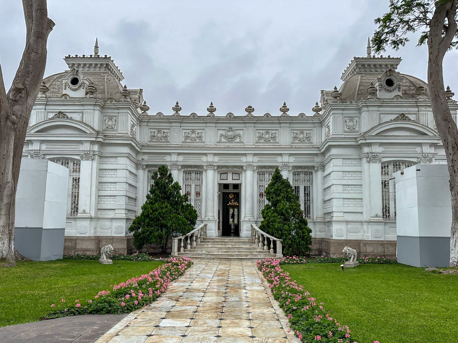 Kolonialpalast in Grau mit Garten davor