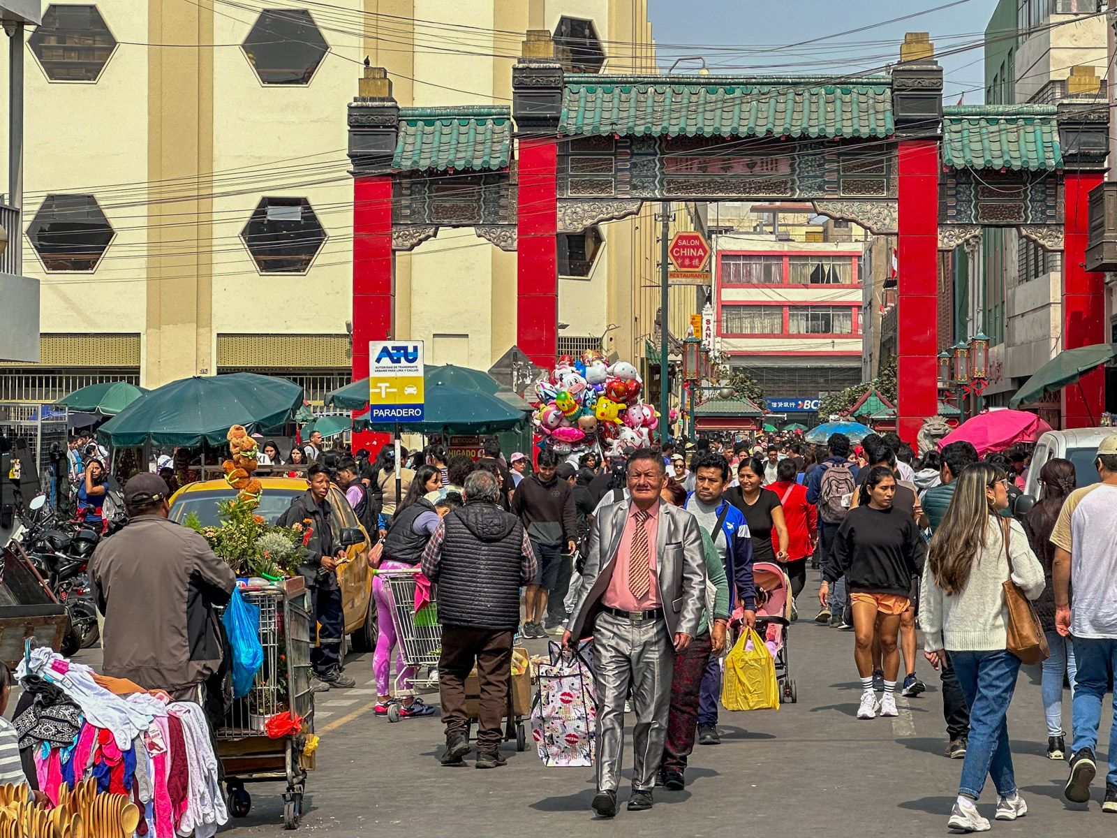 Eingangstor zur Chinatown und viele Menschen mit Einkaufstaschen