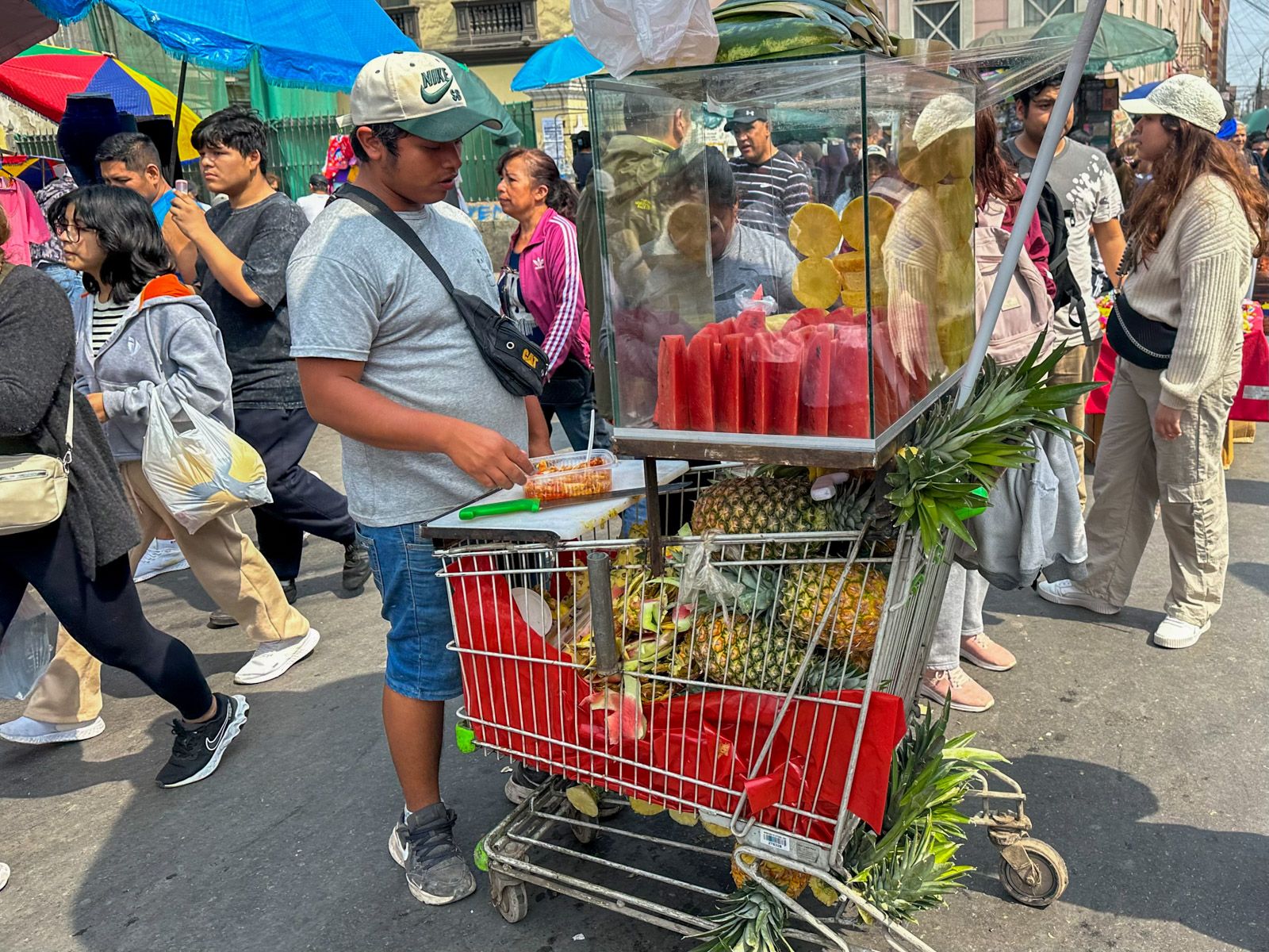 Mann verkauft Ananas aus dem Einkaufswagen
