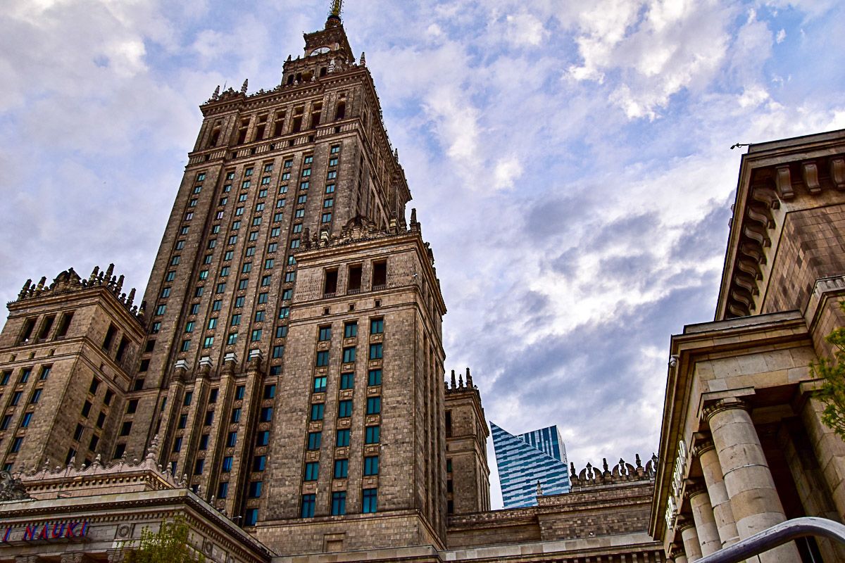 Ein historischer Wolkenkratzer mit mehreren Türmen und ein Wolkenkratzer der Moderne im Hintergrund 
