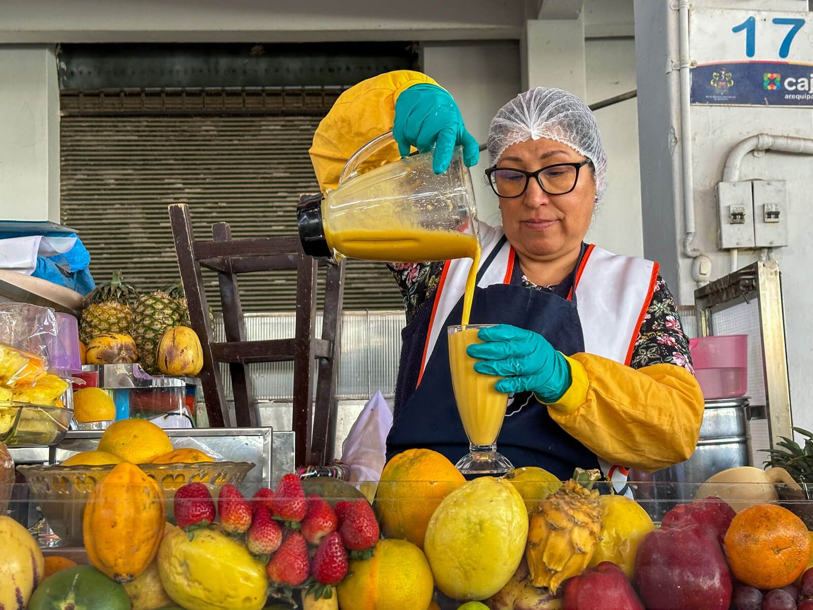 Sehenswürdigkeiten Arequipa: Verkäuferin schenkt Fruchtsaft auf dem Mercado Camilo ein