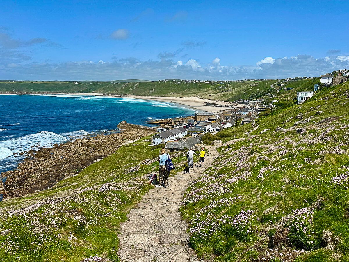 Cornwall: Wanderer auf einem Wanderweg mit Blick auf die Küste