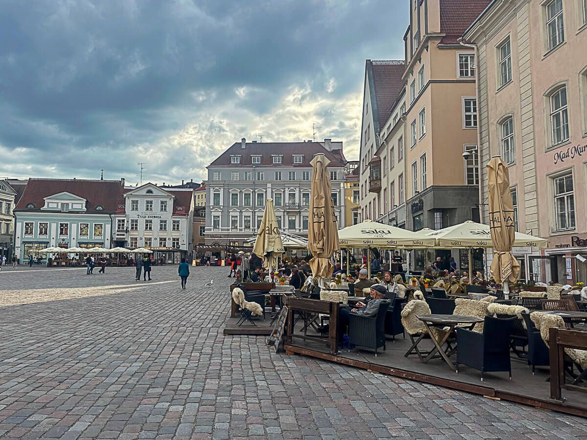 Altstadtplatz mit historischen Häusern. Davor Lokale, in denen viele Menschen sitzen