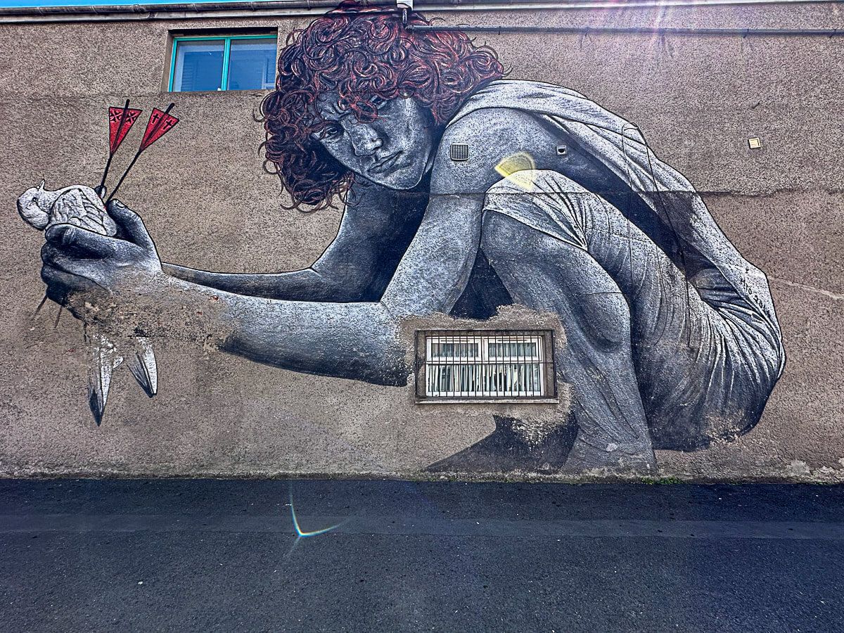 Mural mit einem rotgelockten Jungen, der eine tote taube in Händen hält