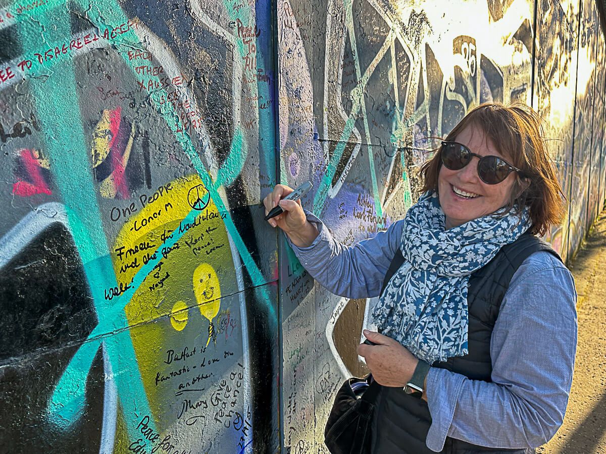 Frau bei Beschriftung der Peace Wall