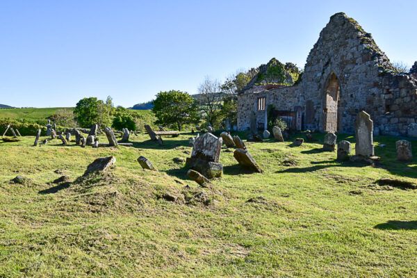 Kirchenruine und windschiefe Grabsteine davor