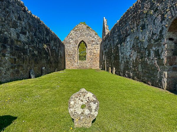 Kirchenruine mit einem runden Grabstein