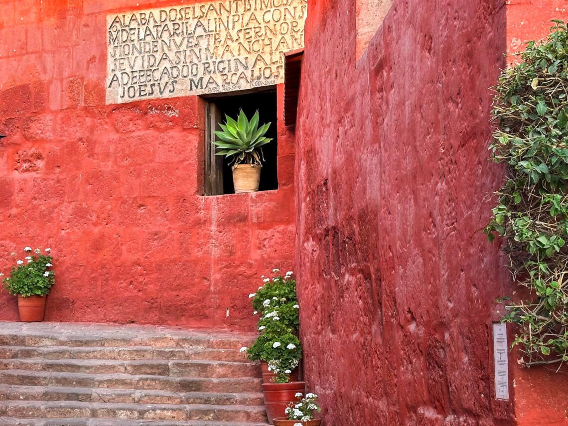 Roten Wände eines Kloster, Nischen mit Blumen und eine Treppe