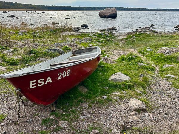 Roadtrip Estland 1 Woche: Ostseeküste, Moore und eine coole Hauptstadt 31 rotes Ruderboot am Strand. Dahinter Findling im Meer