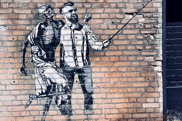 Roadtrip Estland 1 Woche: Ostseeküste, Moore und eine coole Hauptstadt 16 Mural an Backsteinmauer, das einen Mann mit Selfiestick und ein Skelett zeigt