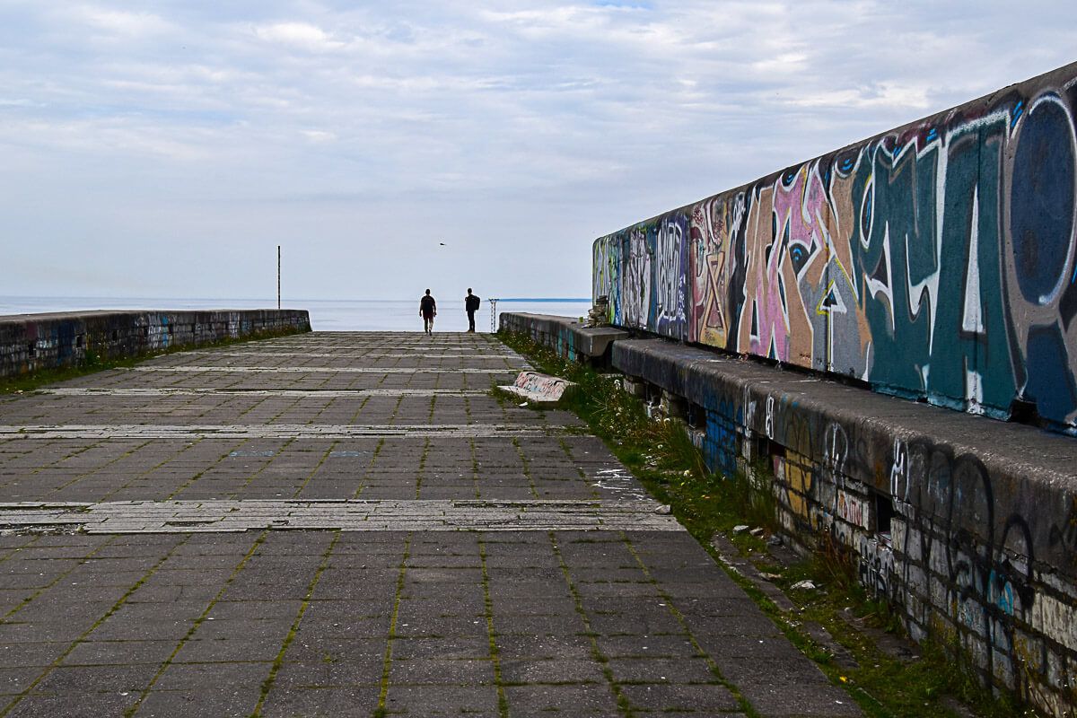 Aufgang zur Linnahall mit zwei Menschen und einer bunt bemalten Wand