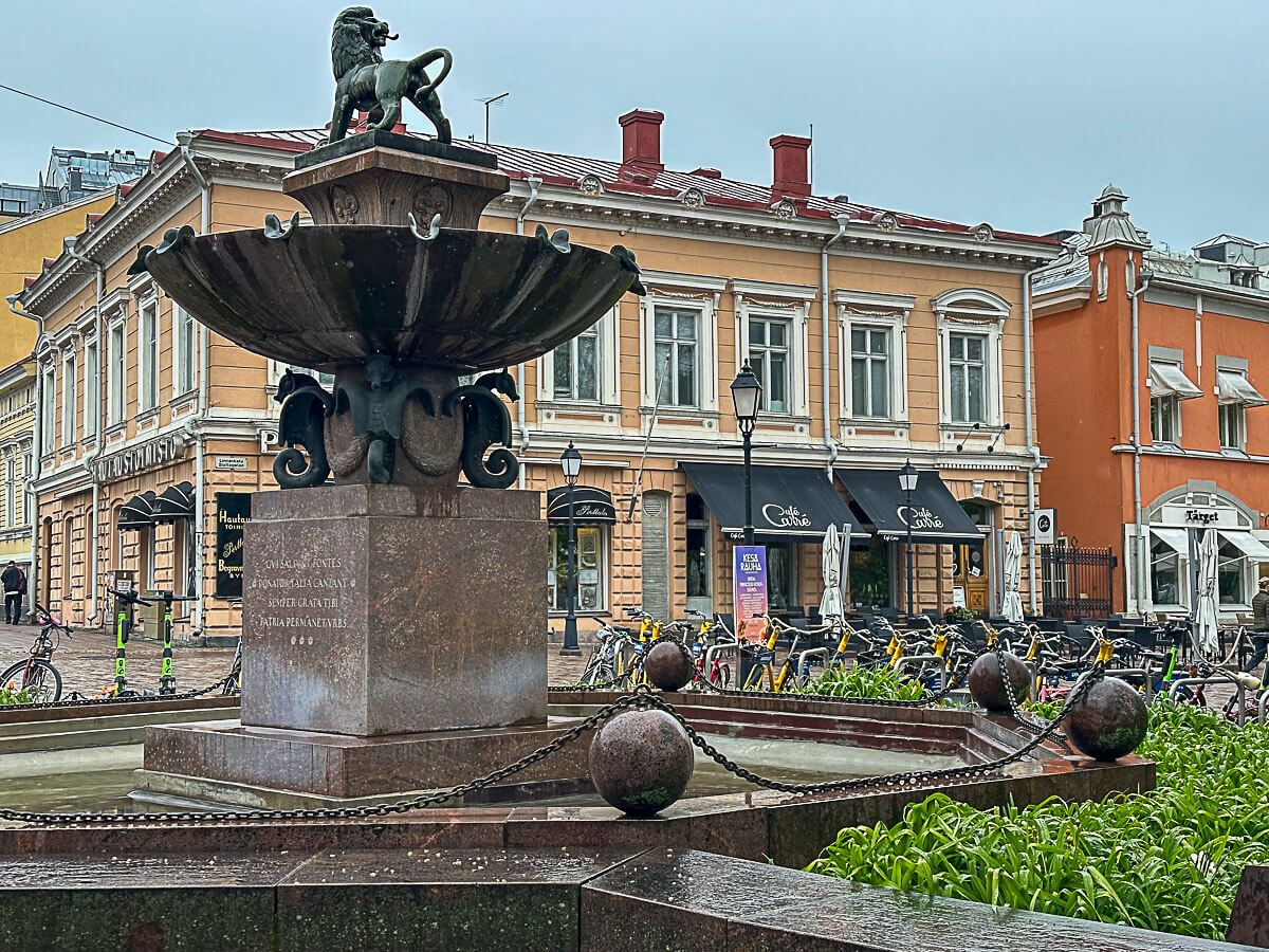 Mit dem Zug durch Finnland: Helsinki – Turku – Tampere 28 gelbes Holzhaus mit Brunnen davor