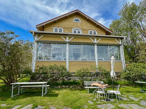 Mit dem Zug durch Finnland: Helsinki – Turku – Tampere 46 Turku, Insel Ruissalo: gelbes Holzhaus in einem Garten mit Tisch und Stühlen davor