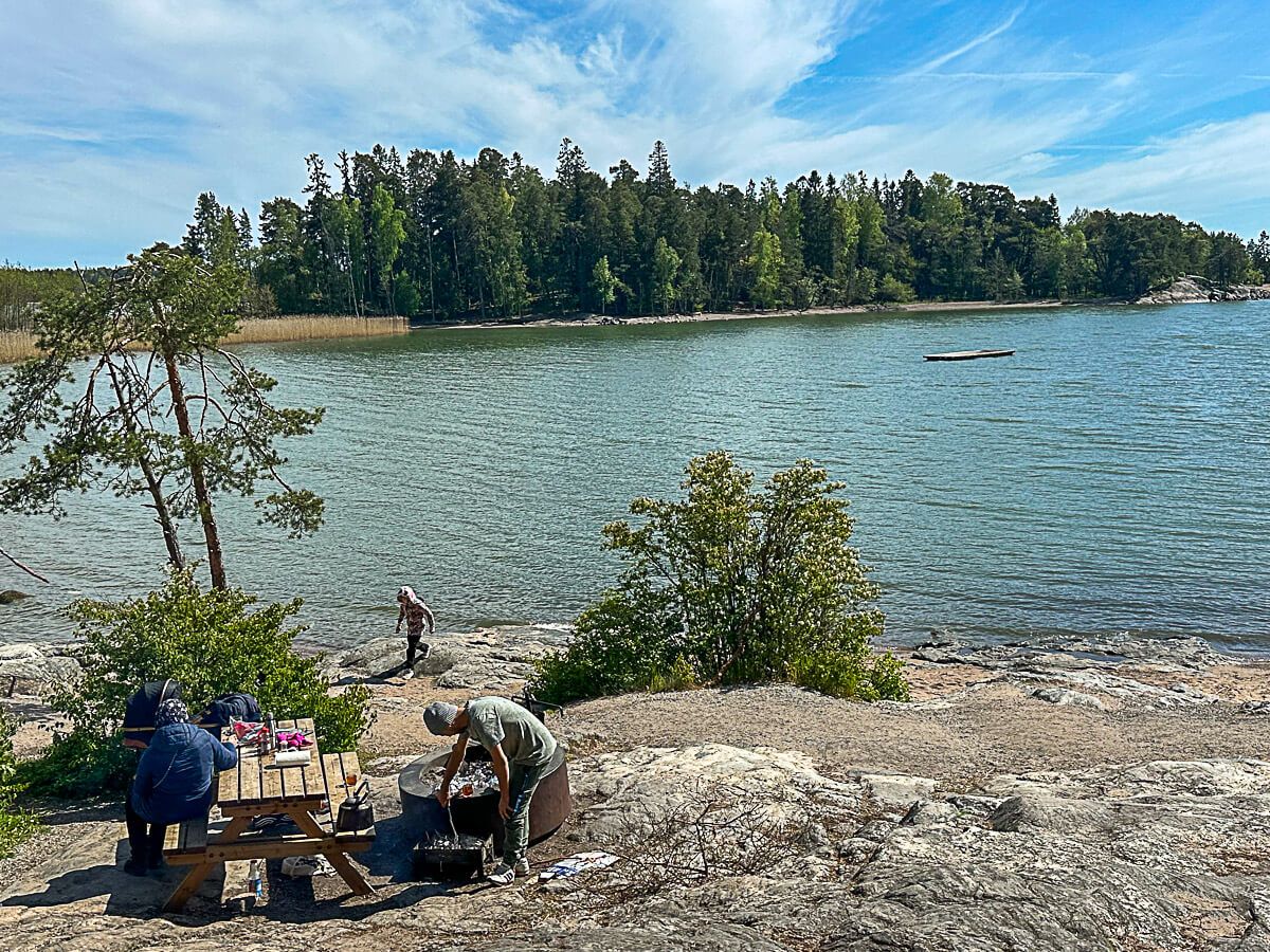 Mit dem Zug durch Finnland: Helsinki – Turku – Tampere 49 Strand auf der Insel Ruissalo mit Menschen beim Picknick an einem Picknicktisch