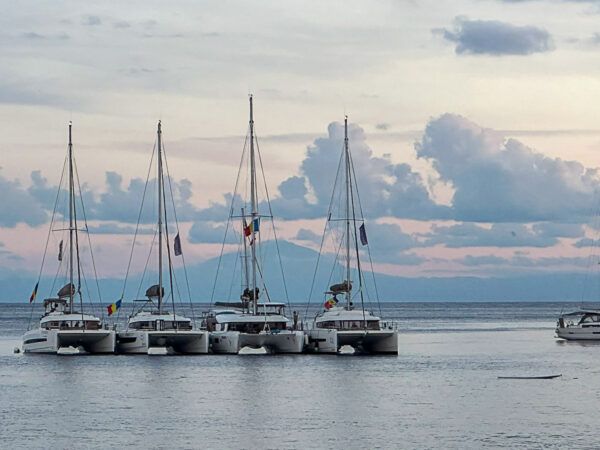 Vier Boote in einer Reihe, dahinter der Stromboli