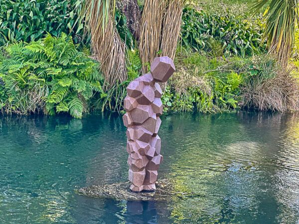 Moderne Statue eines Mannes, der im Fluss steht.