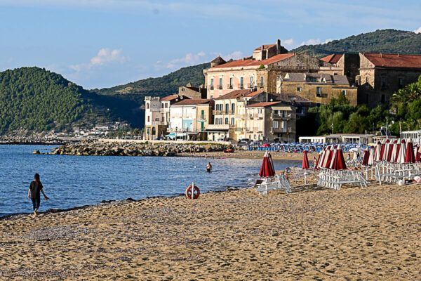 Sandstrand mit Liegen und Sonnenschirmen, dahinter die Altstadt