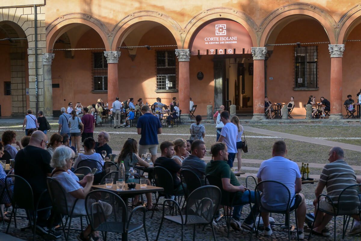 Zwei Stadtperlen der Emilia-Romagna: Sehenswürdigkeiten in Bologna und Ravenna auf der Durchreise 22 Platz mit einer Bar, in der viele Menschen sitzen