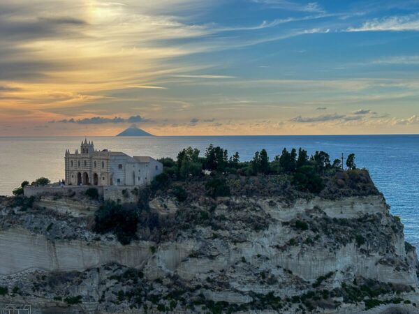 Kirche auf einem Felsen in Tropea, am Horizont der Vulkan Stromboli