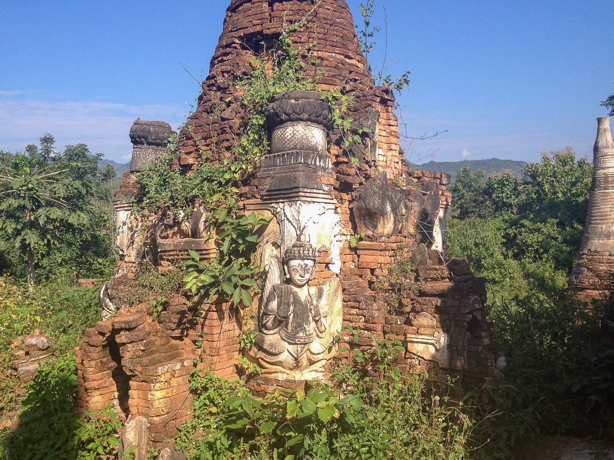 Buddhafigur an einer verfallenen Pagode 