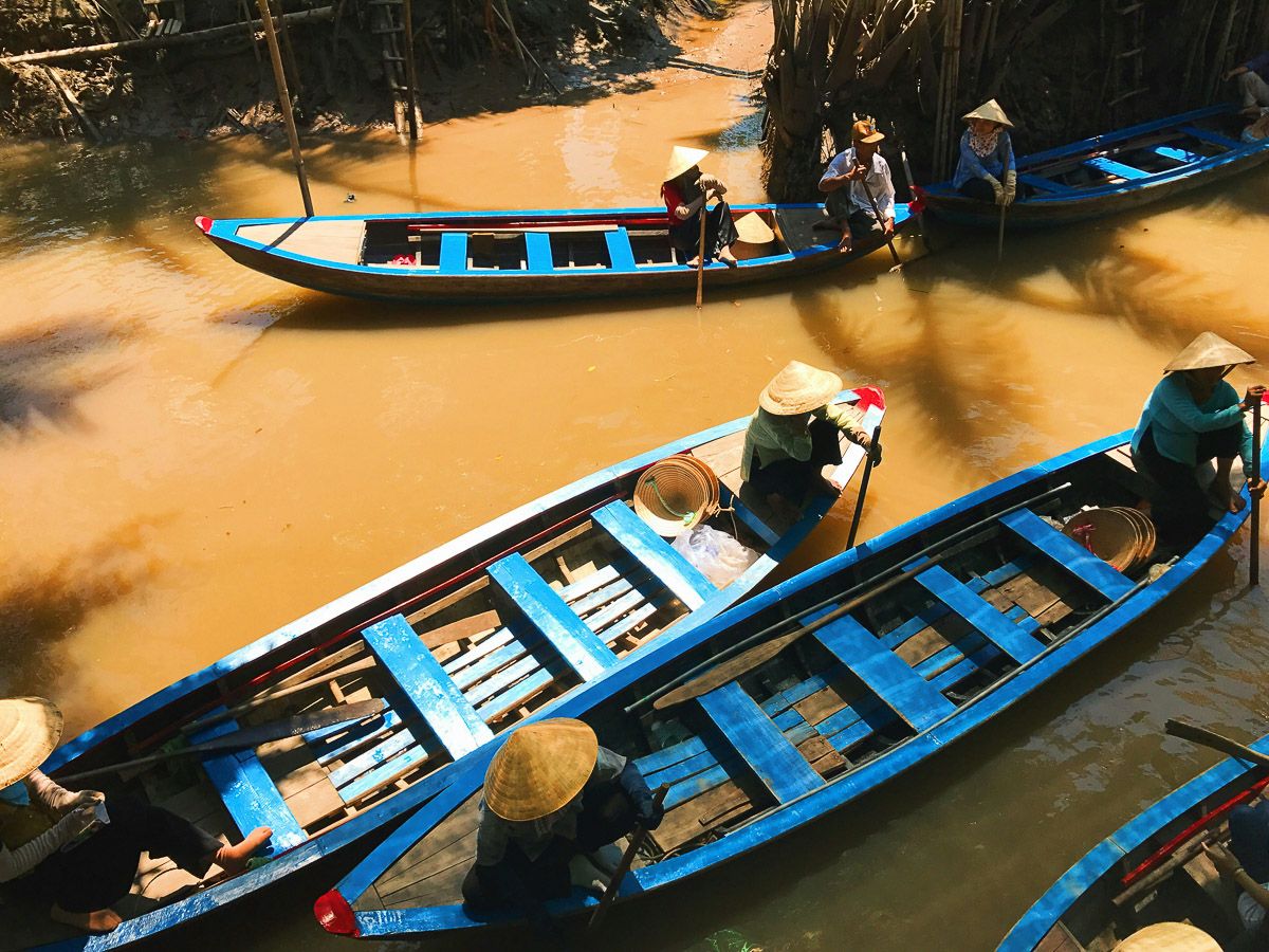 Ruderboote mit Verkäuferinnen auf einem Markt in den Kanälen des Mekong-Deltas