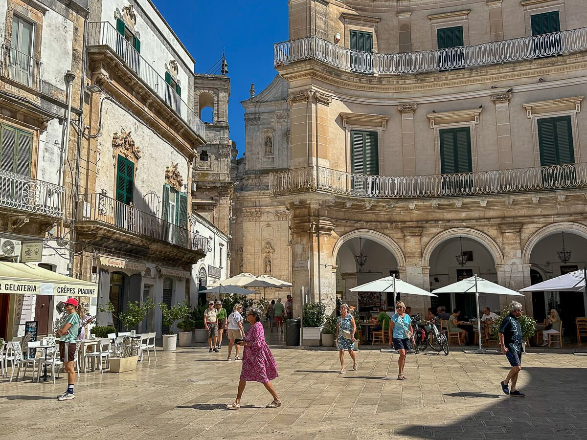 Hauptplatz von Martina Franca mit Passanten. Im Hintergrund die Kathedrale
