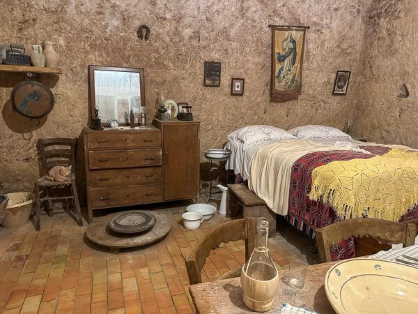 Höhlenwohnung mit Tisch, Bett und Kommode