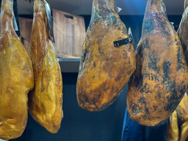 Schinken baumeln über einer Bartheke