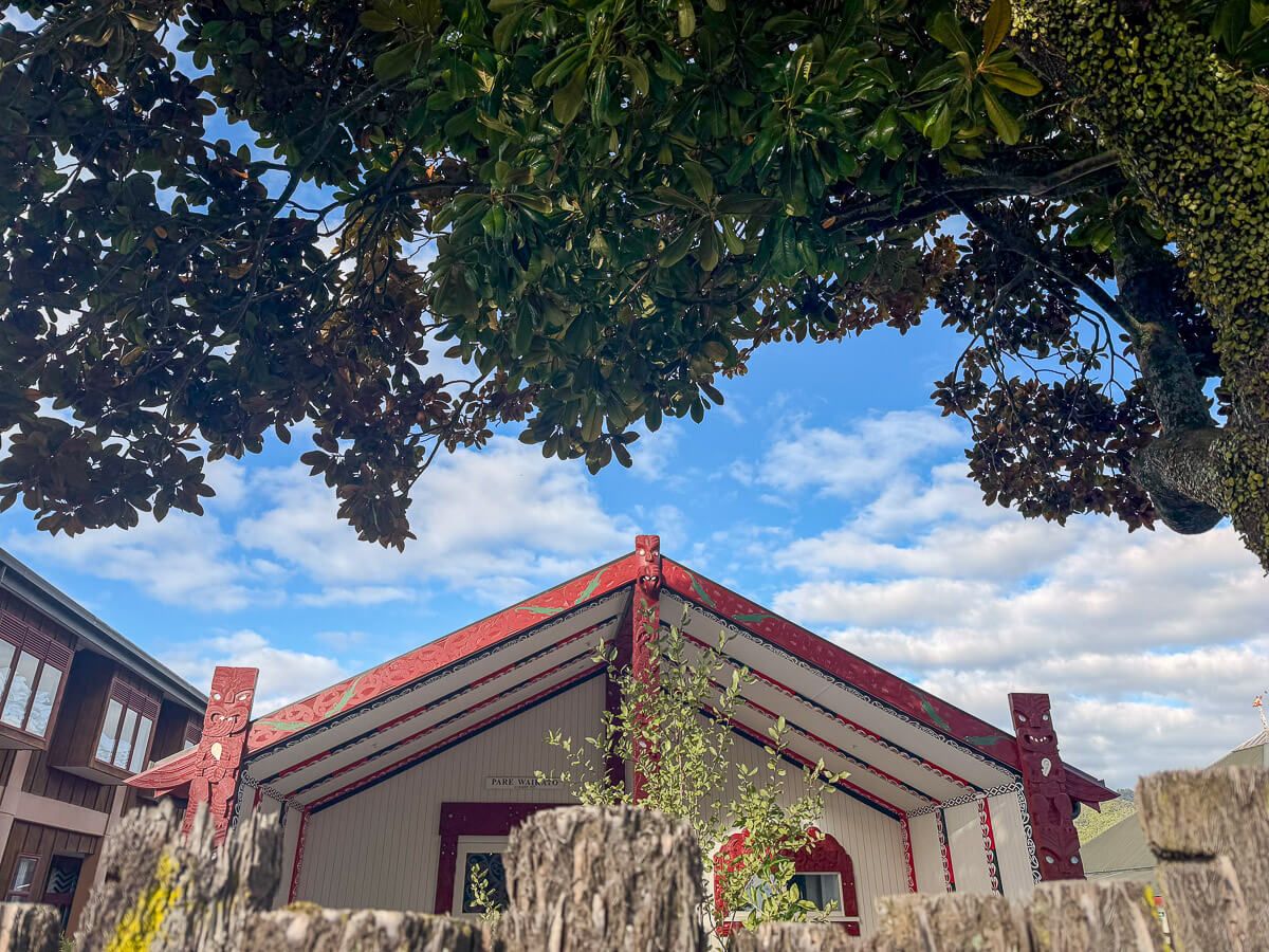 Dach eines Maori-Versammlungshauses hinter einem Zaun