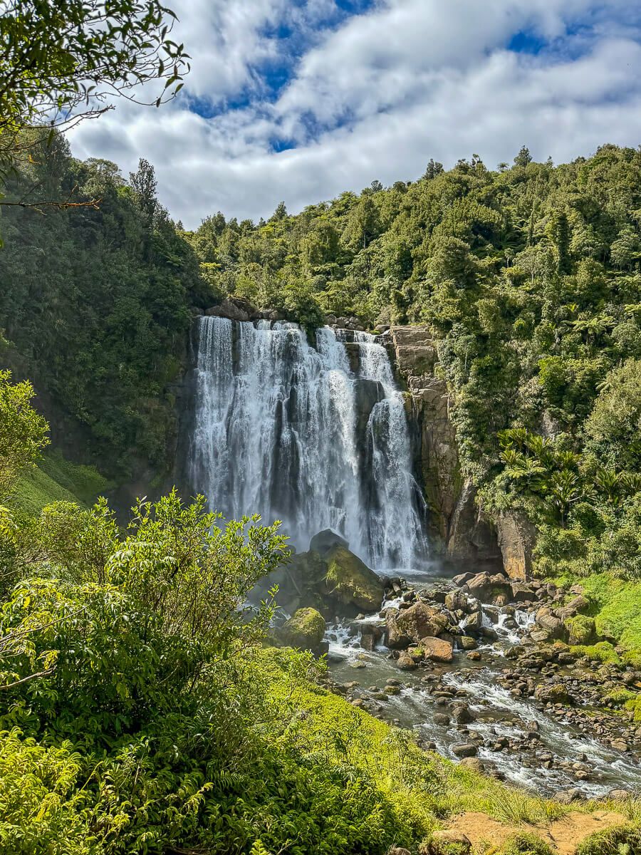 Breiter Wasserfall, der sich in einen Fluss im Regenwald ergießt