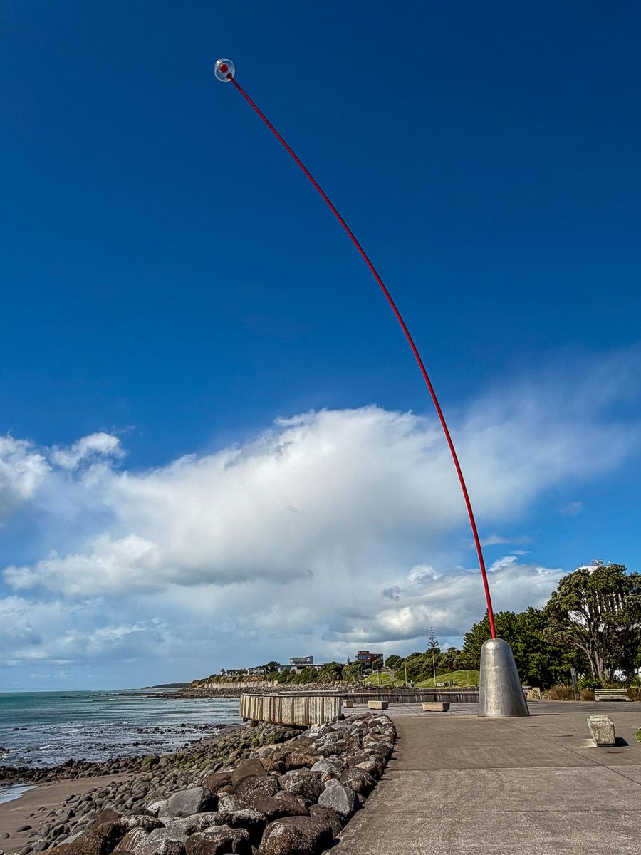 Neuseeland: Reisetipps für Mount Taranaki und New Plymouth 12 Installation "Wind Wand" von Len Lye: ein roter Stab, der sich im Wind wiegt, am Coastal Walkway