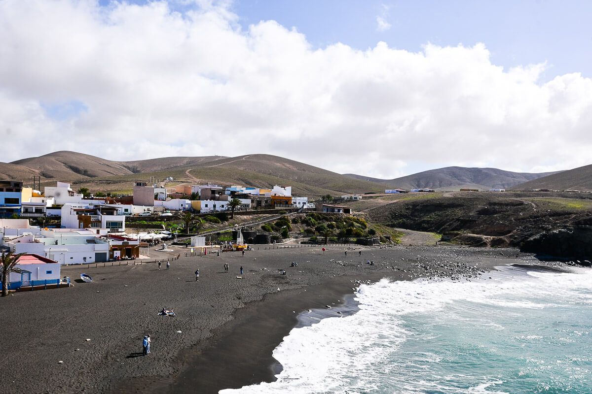 Schwarzer Strand mit Fischerdorf 