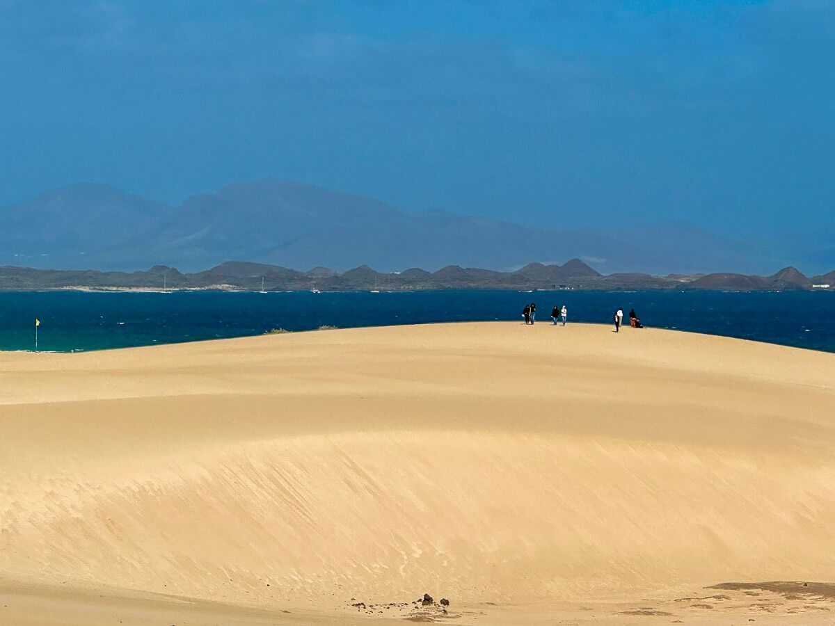 Reisetipps Fuerteventura: Riesige Düne vor Meer; im Hintergrund Berge