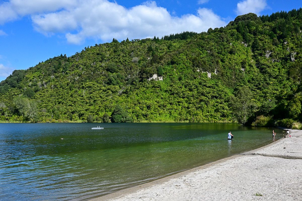 Badestrand an einem See, der von Wald umgeben ist