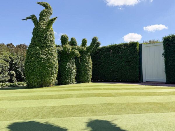 Surrealistischer Garten mit übergroßen Buchsbäumen und einer riesigen Tür in den Hamilton Gardens 