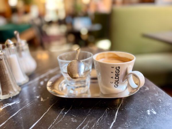 Mit Schmäh und Patina: Die 13 besten Kaffeehäuser in Wien 8 Tasse mit Kaffee und Glas mit Wasser auf dem Tisch eines Wiener Kaffeehauses