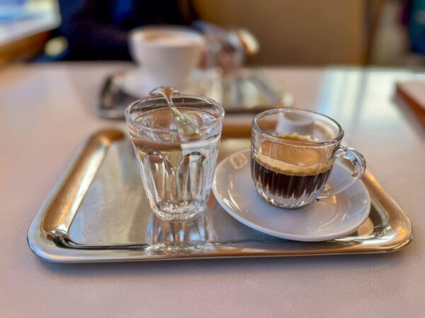 Silbertablett mit Glas mit Mokka und Wasserglas
