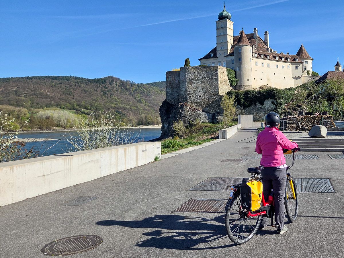 Radlerin vor Schloss an der Donau