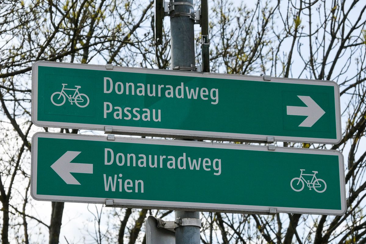 Schild mit Hinweis zu den beiden Richtungen des Donauradwegs