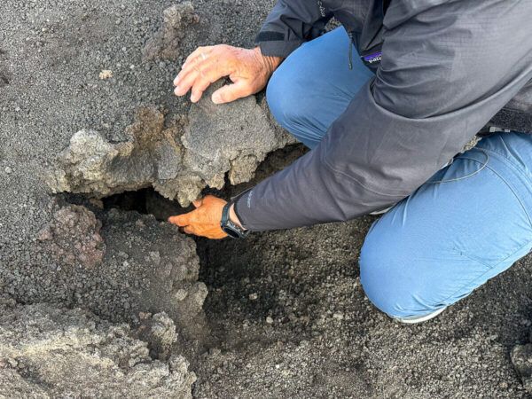 Wanderer prüft heiße Luft aus Grube