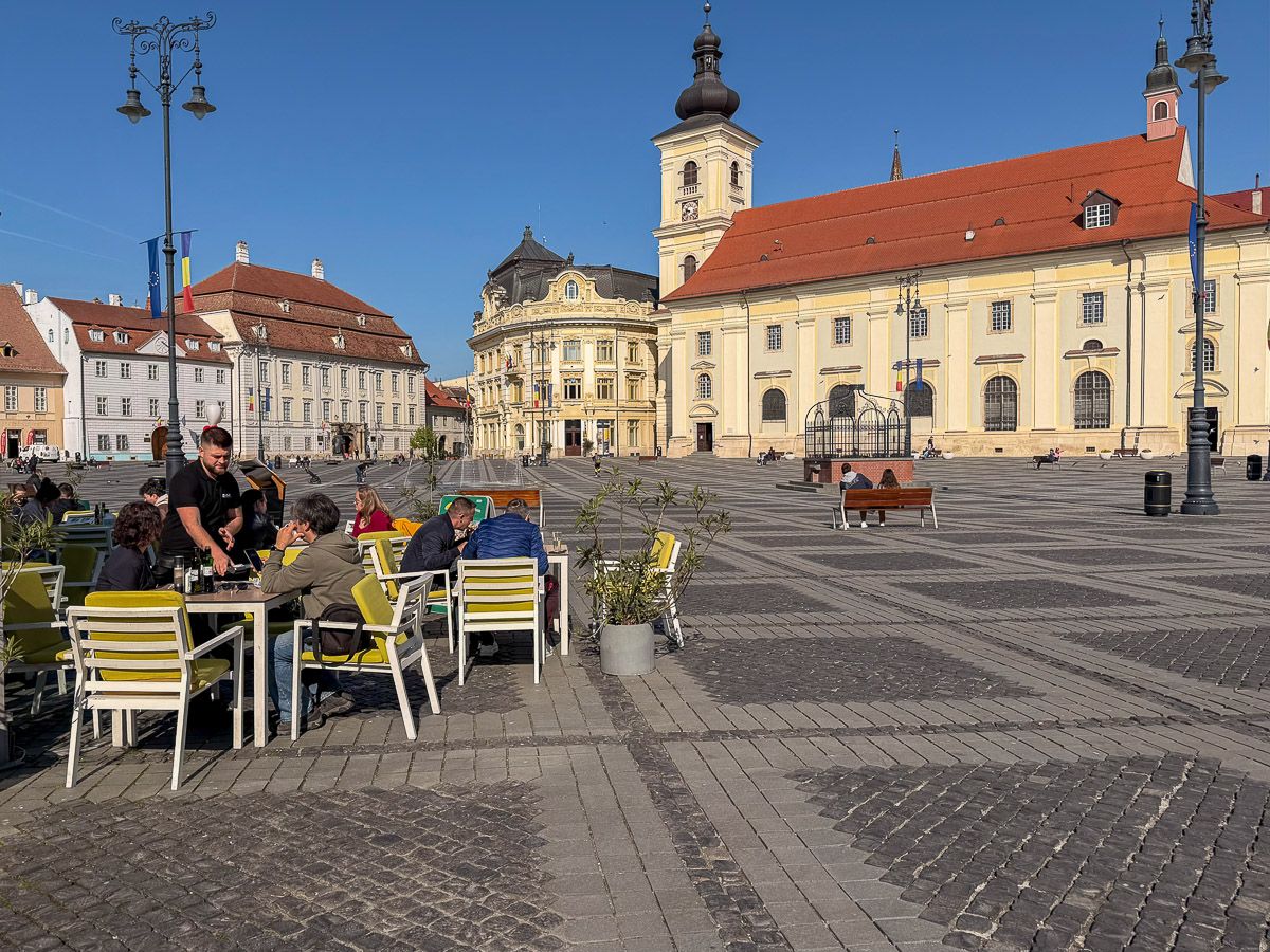 Blick auf den Großen Ring mit Café im Vordergrund und Katholischer Kirche im Hintergrund