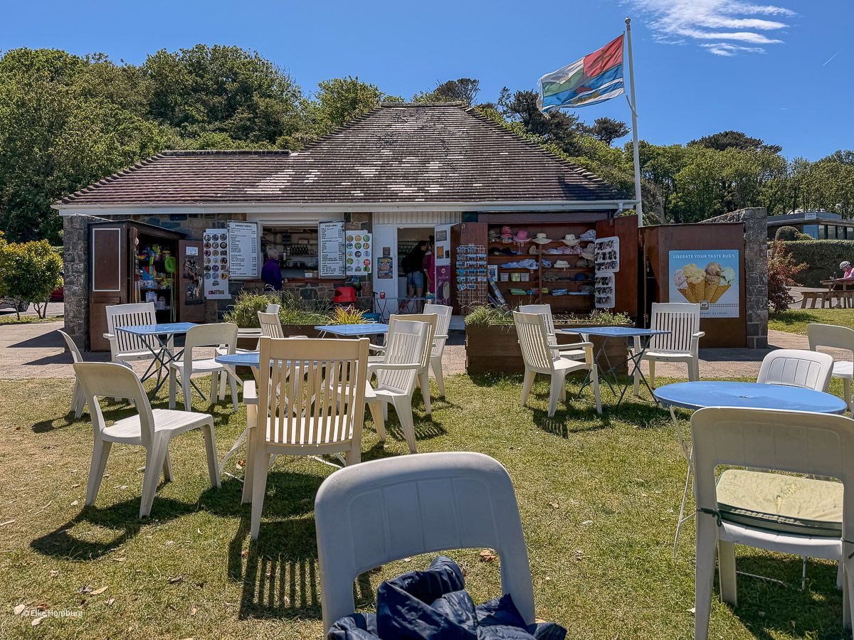 Kiosk am Strand mit Tischen auf dem Rasen