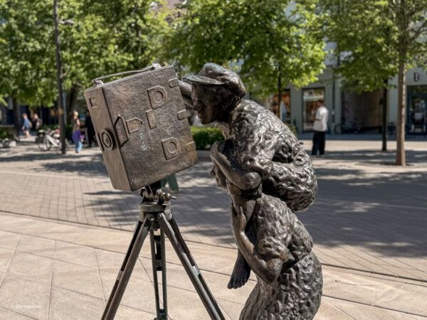 Skulptur, die zwei Jungs hinter einer Filmkamera zeigt
