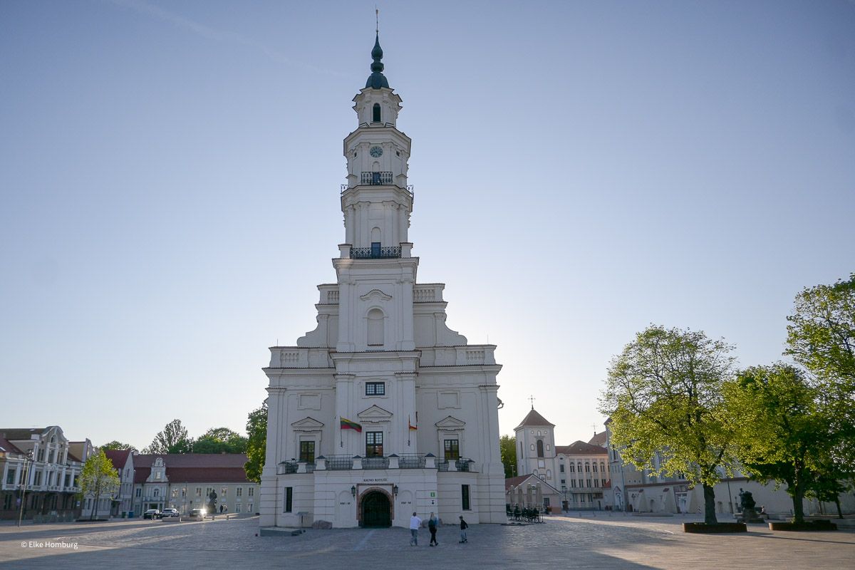 Gebäude mit weißem Turm auf einem großen Platz