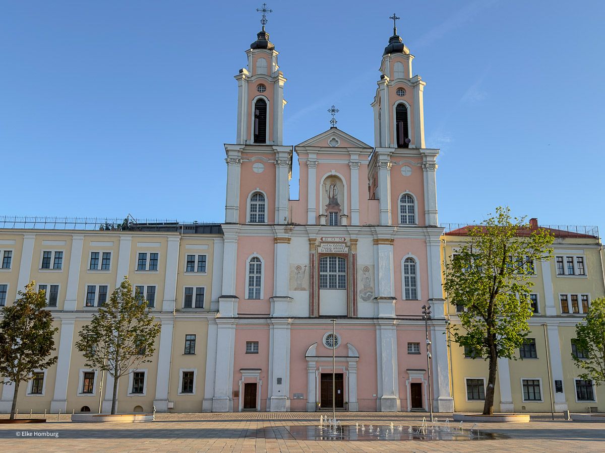 Rosafarbene Kirche, die in ein Gebäudeensemble eingebunden ist