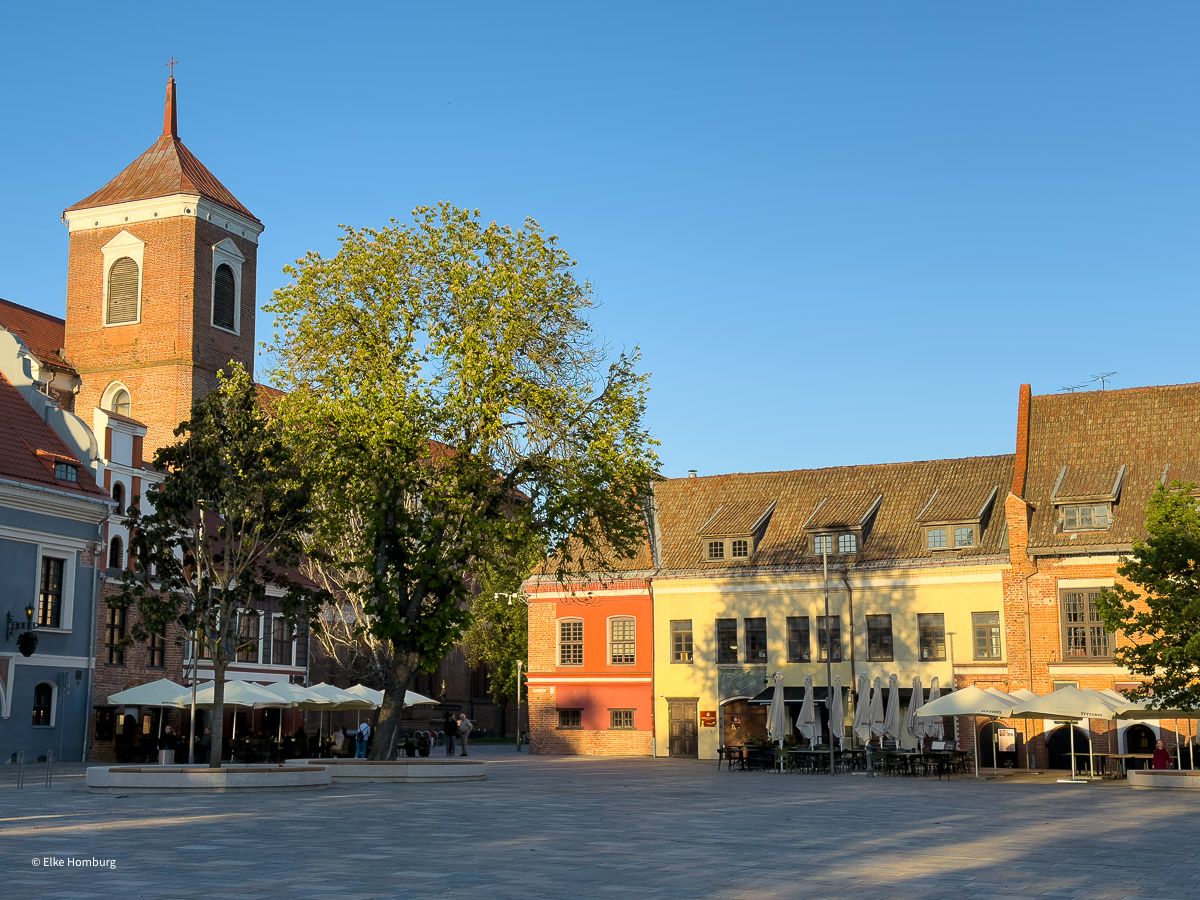 Platz mit Kirchturm und Häusern mit Restaurants